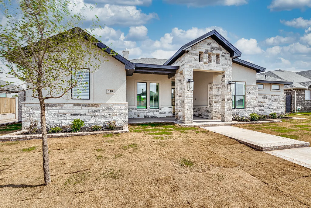 Angled front elevation showing stone facade and entry walkway of new home at 119 Rolling Winds Circle