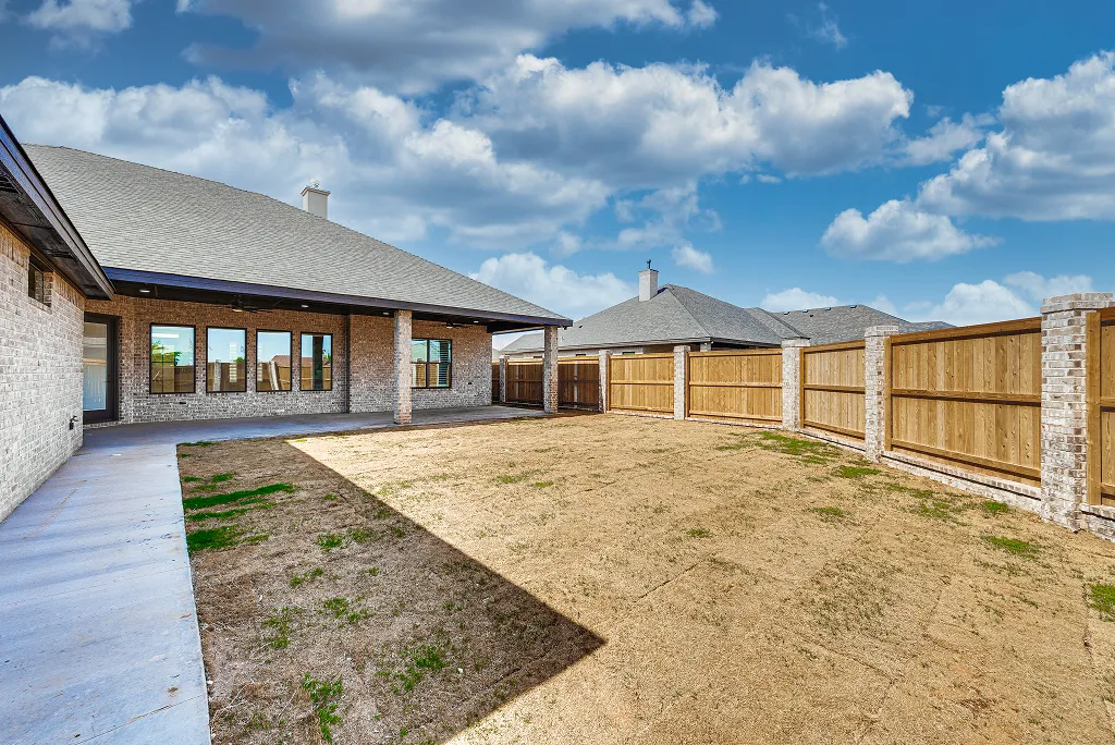 Fenced backyard with grassy area and side gate at 119 Rolling Winds Circle