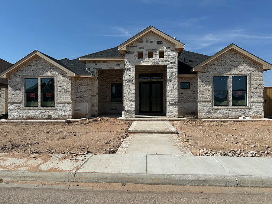 New brick house under construction with stone pathway. At Rolling Winds in Odessa TX